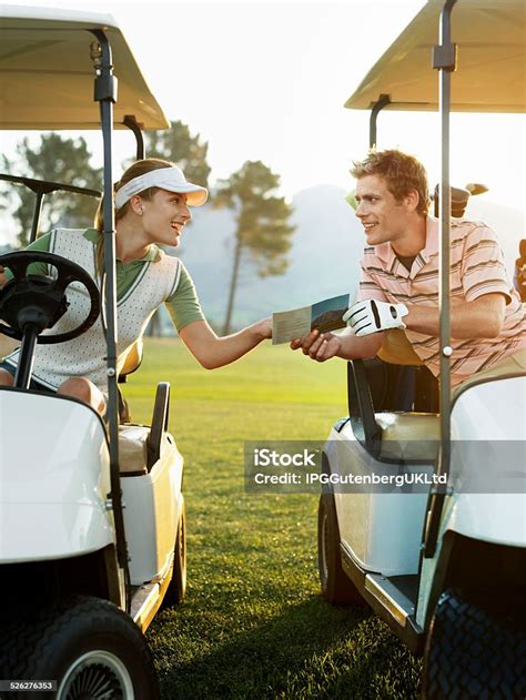 Golfers Sitting In Golf Carts Holding Score Card Stock Photo Download