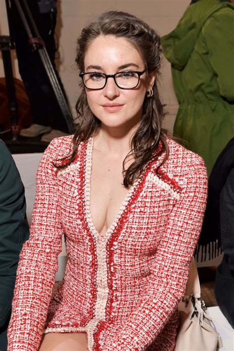 A Woman Wearing Glasses Is Sitting Down