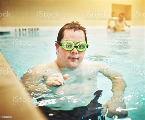 Down Syndrome Disability And Autism Man In Swimming Pool For Physical