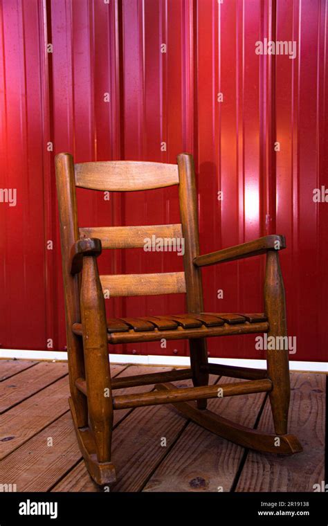 Wooden Childs Rocking Chair On Porch With Metal Siding Stock Photo Alamy