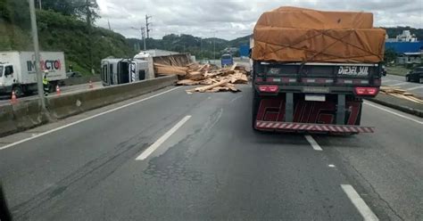 VÍDEO Caminhão carregado de madeira tomba e causa congestionamento na