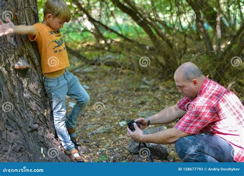 Een Man Fotografeert Een Jongen In Een Bos Op De Natuur Tegen De Achtergrond Van Een Grote Boom