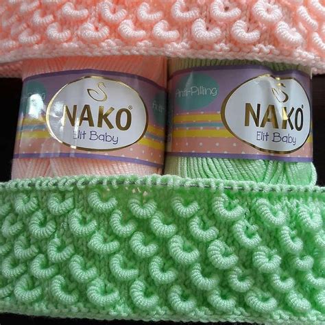 Two Cans Of Nako Are Sitting On Top Of A Knitted Blanket In Pink And Green