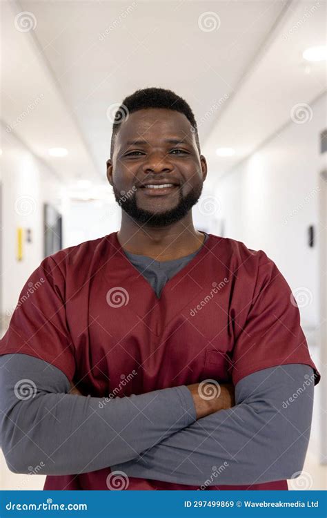 Portrait Of Happy African American Male Doctor In Hospital Corridor