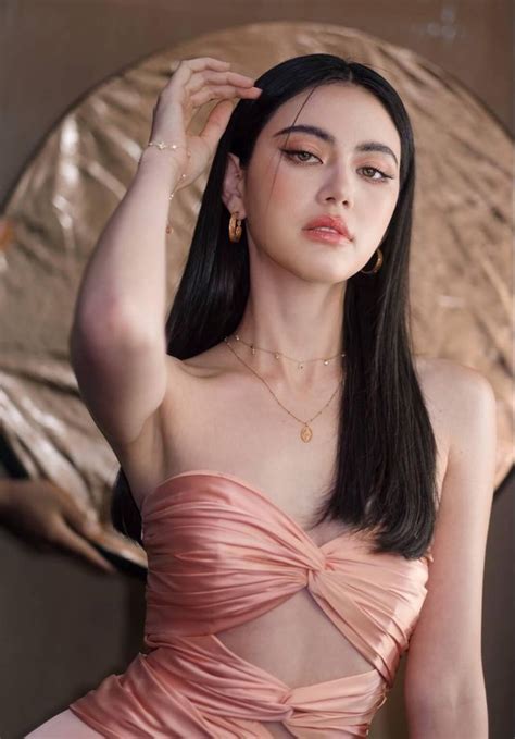 A Woman With Long Black Hair Wearing A Pink Dress And Holding Her Hand