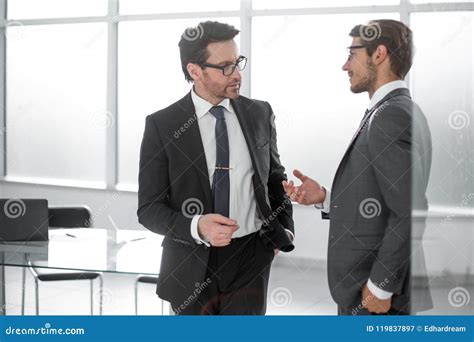 Two Businessmen Discussing Business Issues Standing In The Office