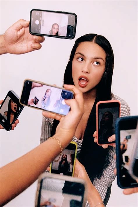 A Group Of People Holding Up Cell Phones In Front Of One Another With