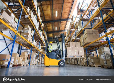 Trabajador de almacén con carretilla elevadora fotografía de stock