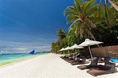 Sun Umbrellas And Beach Chairs On Tropical Coastline Stock Image