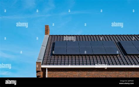 Newly Build Houses With Solar Panels Attached On The Roof Against A