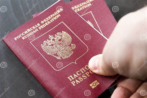 Two Russian Passports In Hand Russian Official Document On Wooden