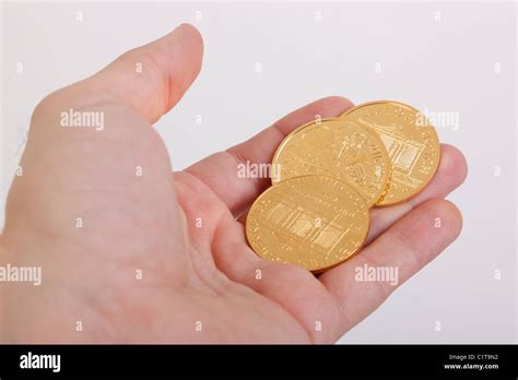 Las monedas de oro en la mano Fotografía de stock Alamy