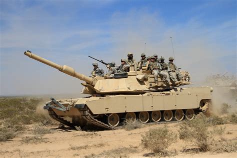 Us Soldiers Riding On Top Of An M1a2 Abrams Tank During A Combined Arms Live Fire Exercise