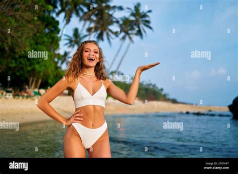 Cheerful Woman In Bikini Presenting With Hand On Beach Smiling Female