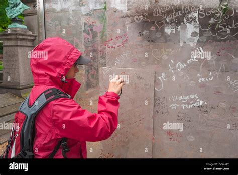 Pere Lachaise un joven turista graffiti fotografías en la pantalla de