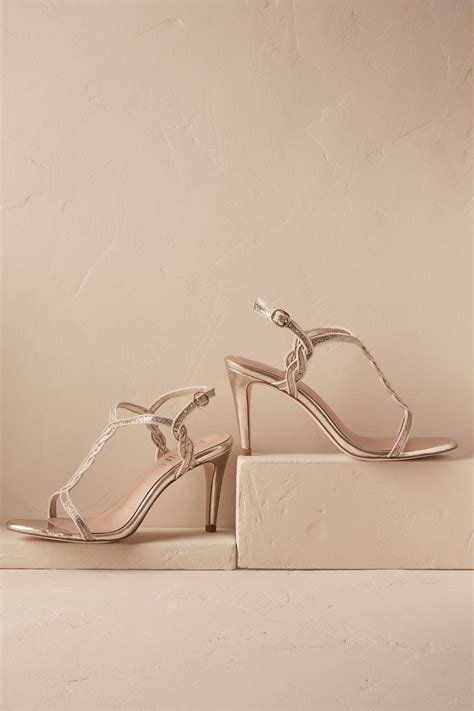 A Pair Of Women S Shoes Sitting On Top Of A White Block Heeled Sandal