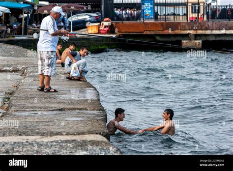 Men Play Adjacent To A Dock In The Bosphorus At Findikli In Istanbul In