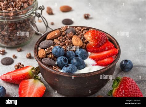 Schokoladengranola mit griechischem Joghurt frischen Beeren und Nüssen