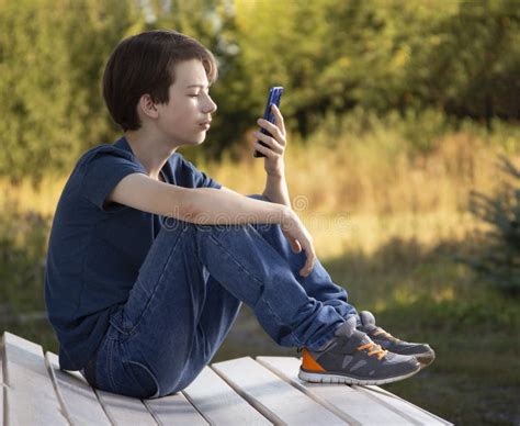 Adolescente Segurado Em Smartphone Manual Garoto Olha No Celular E