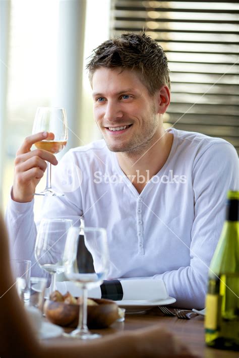 Portrait Of A Handsome Guy Holding A Glass Of Wine At A Restaurant