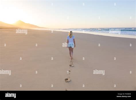 Lady Walking On Sandy Beach In Sunset Stock Photo Alamy