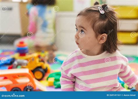 Adorable Chinese Toddler Sitting On Floor With Relaxed Expression At