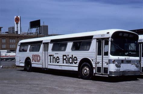 Two White Buses Parked Next To Each Other In A Parking Lot With