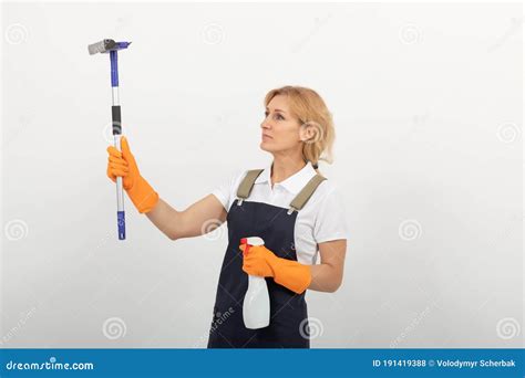 Portrait Of Cleaning Lady Or Housewife Holding A Window Cleaning Brush And A Spray Wearing A