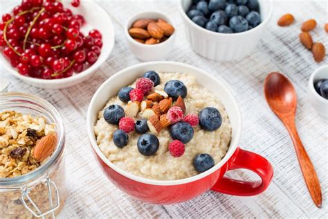 Oatmeal Porridge With Berries And Nuts On White Table Stock Photo