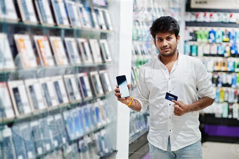 Indian man customer buyer at mobile phone store choose his new
