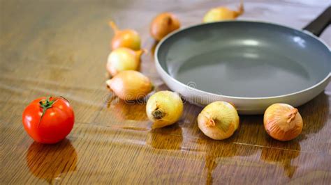 Cooking Onions And Tomatoes Dance Around The Frying Pan Stock Photo