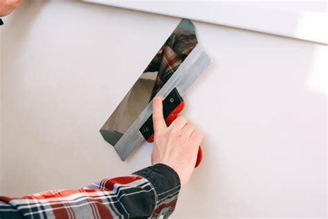 Premium Photo Construction Worker Puttying A White Wall