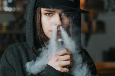 Joven Mujer Bonita Con Gorra Roja Fumar Un Cigarrillo Electrónico En La