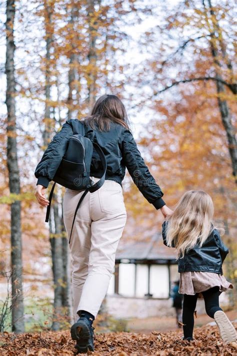 Madre Y Una Niña Caminan Rápidamente Por Un Parque De Otoño Tomándose