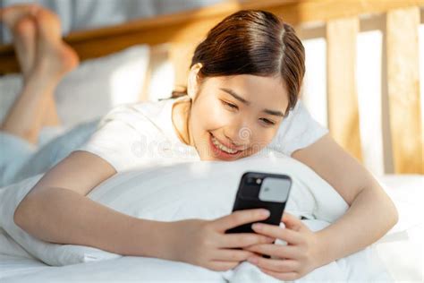 Beautiful Asian Woman Using Her Phone When She Just Wakes Up Stock