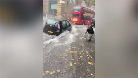 Man Brushes Away Water As Heavy Rain Hits Kings Cross News