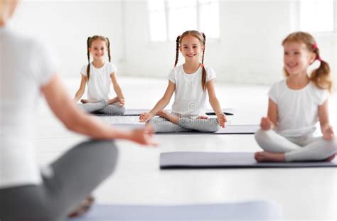 Enfants Pratiquant Le Yoga Dans Une Pose De Lotus Avec Le Professeur