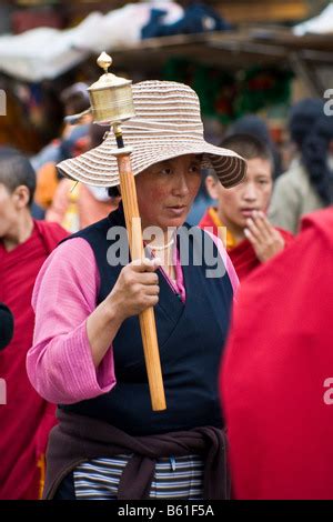 Tibetan Men And Woman Pilgrims Spinning The Enormous Prayer Wheel At