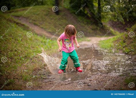 Kid Jumping Into Water Puddle Stock Photo Image Of Emotions Autumn