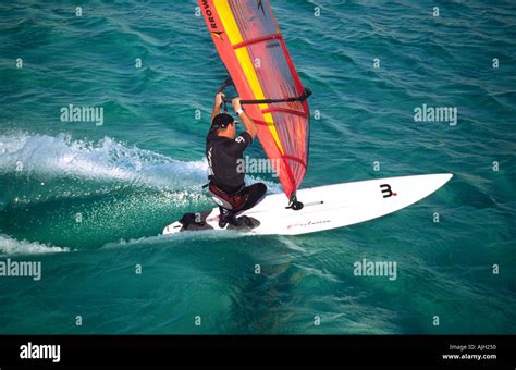 Aerial View Of Single Male Windsurfer Sailing On Light Green Blue Water