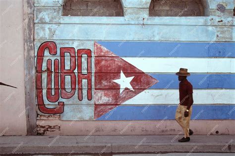 Premium Photo | Old man in the streets of havana cuban flag painted on ...