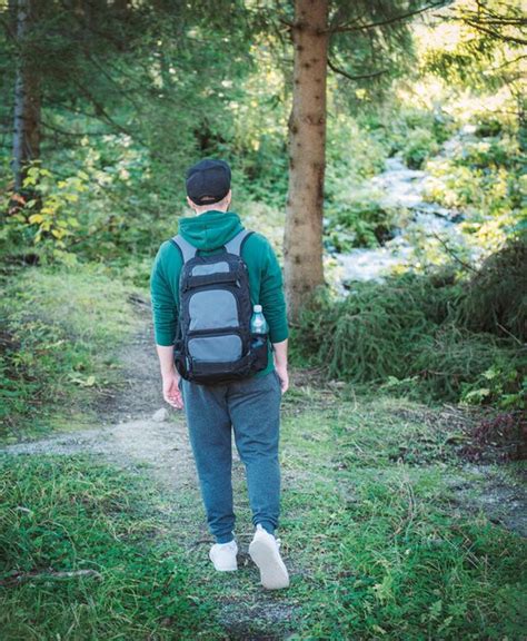 Premium Photo A Man With Backpack Walks In The Autumn Forest Hiking