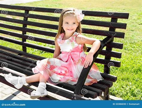 Retrato Exterior Da Menina Que Senta Se Em Um Banco Foto De Stock