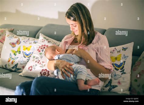 Young Beautiful Mother Breastfeeding Her Newborn Baby Boy At Night