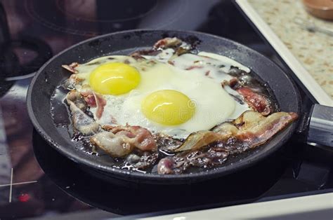 Scrambled Eggs Cooking In A Frying Pan Cooking On A Ceramic Stove Scrambled Eggs With Bacon