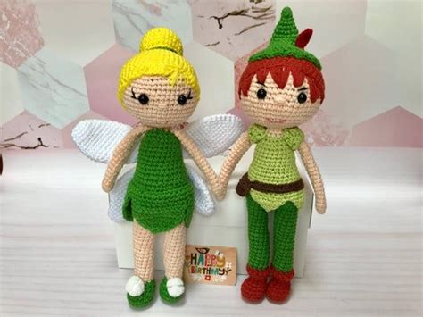 Two Crocheted Dolls Sitting Next To Each Other