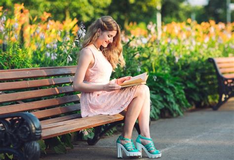 Une Jeune Fille Lisant Un Livre Assis Sur Un Banc Au Coucher Du Soleil