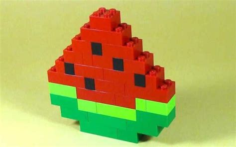 A Toy Made Out Of Legos Sitting On Top Of A Yellow Table Next To A Green And Red Object