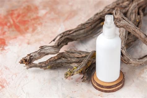 Free Photo Top View Empty Spray Bottle On Wood Board Tree Branch On Nude Background