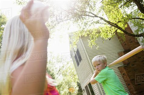 Caucasian children playing baseball in backyard - Stock Photo - Dissolve